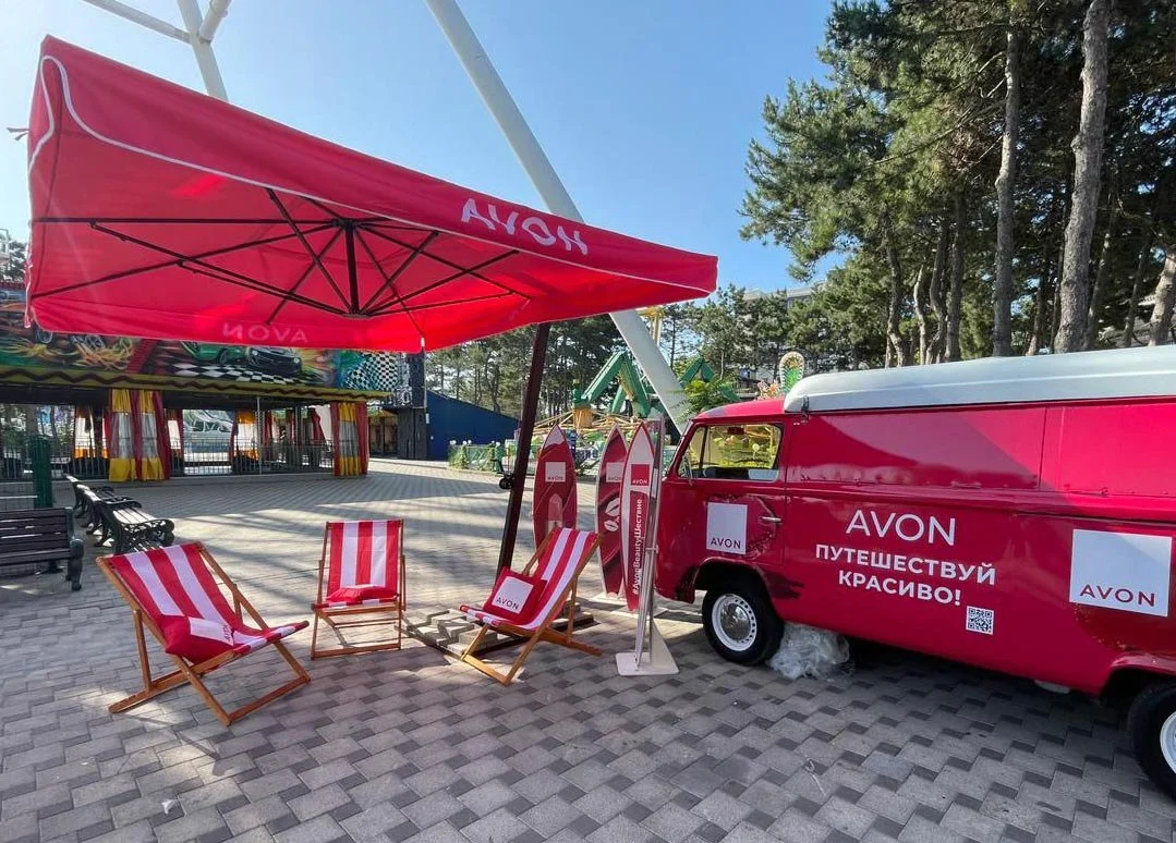 Промо-зона Avon в Сочи — общий план с брендированным автобусом, креслами и зонтом